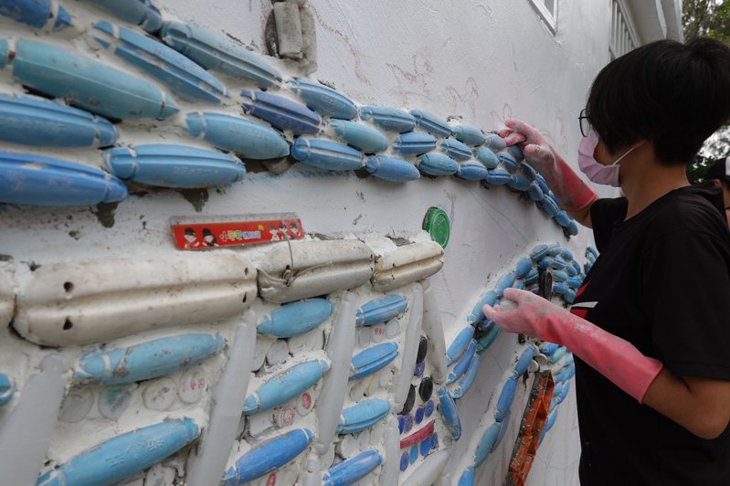 海湧工作室團隊利用千個寶特瓶蓋、800多個漁網藍色浮標等多種海洋廢棄物裝扮牆面。記者陳苡葳／攝影