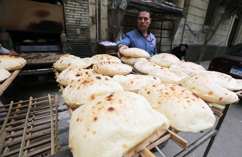埃及的麵包價格已經上漲五成，圖為一位民眾15日在開羅一處市場購買麵包。歐新社