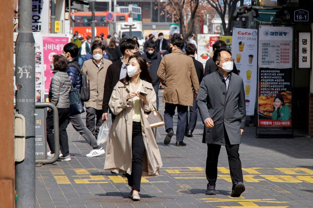 圖為行人在首爾購物街區步行，南韓於3月17日單日出現62萬人確診。 圖／路透社