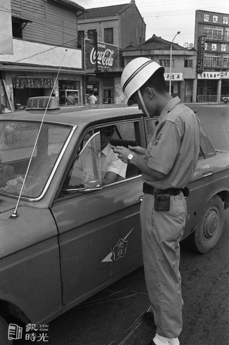 台北市計程車司機穿著制服之規定，勸導期已屆滿，圖為一日開始執行取締鏡頭。日期：1969/7/1．攝影：高鍵助．來源：聯合報