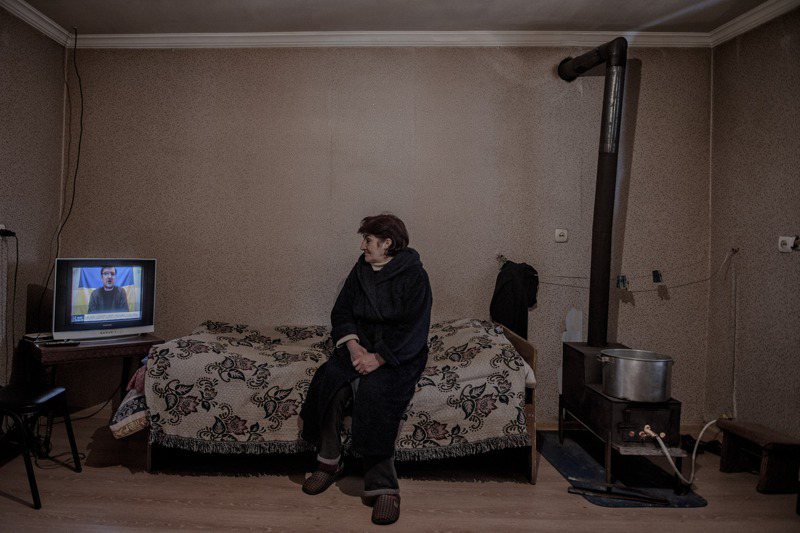 馬戈斯維利13日在庫瓦雷蒂村一處收容營地內觀看有關烏克蘭的新聞報導，俄國入侵烏國讓她想起14年前往事。圖／取自紐時