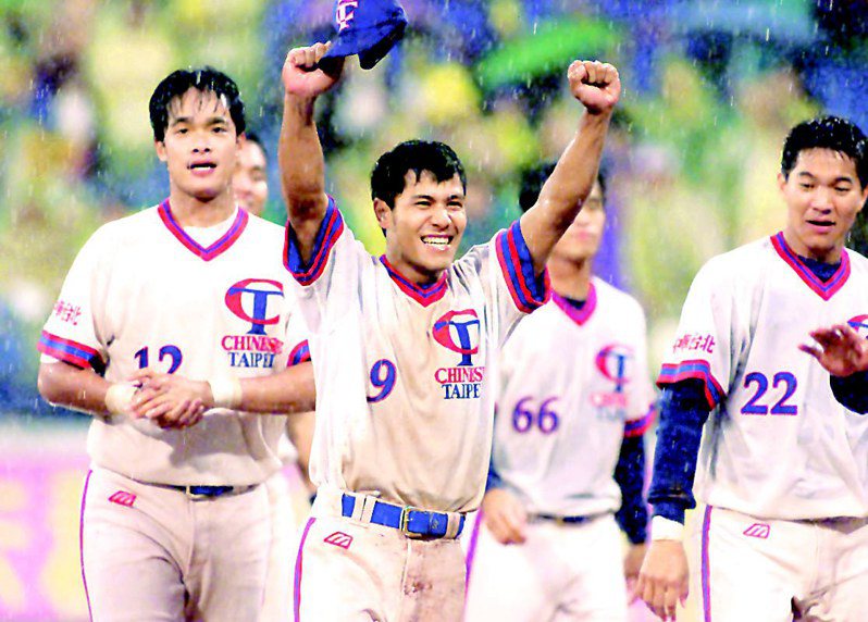 2001年3月25日中華隊王建明（中）冒雨演出雨中滑壘秀後，高舉雙手接受球迷歡呼。圖／聯合報系資料照片
