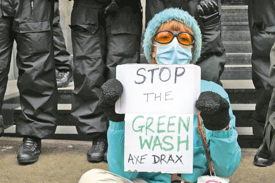 一名婦人去年在COP26場外抗議，手持「停止漂綠」標語。（本報系資料庫）