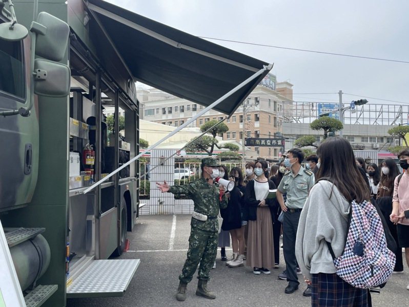 國軍八軍團人員，向台南藥理大學生介紹核子緊急應變裝甲車的設備。圖／台南藥理大學提供