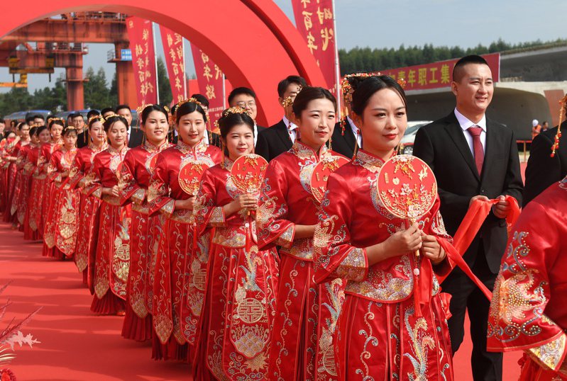 圖為大陸貴南（貴陽至南寧）高鐵武鳴制梁場職工集體婚禮，來自中鐵上海工程局工程建設一線的64對新人身穿中式傳統婚服。新華社