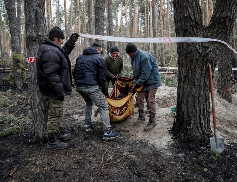 布查當地居民繼續挖掘遭俄軍殺害的平民，從亂葬崗抬出屍體。 路透社