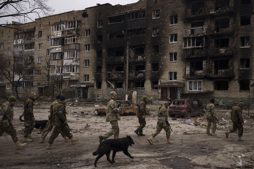2022年4月6日，烏克蘭基輔郊區的Irpin，烏克蘭士兵在
嚴重受損的住宅樓旁行走。 圖／美聯社