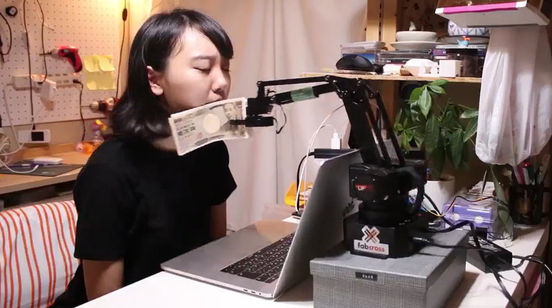日本無用小物發明家藤原麻里菜近日又發表新作「鈔票搧臉機」，希望能替上班族找回努力工作的動力。 圖／擷自影片