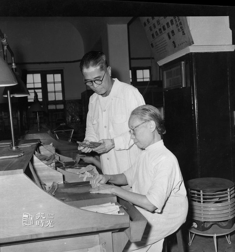 圖說：台北菸廠服務最久的員工賴理(坐者)，是該廠雪茄部門技術最佳的一位女工，站立者為菲律賓籍男性技士易路生。日期：1957/09/29。攝影：陳明輝。來源：聯合報
