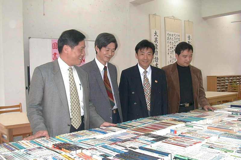 1974年桂冠圖書公司成立，創辦的賴阿勝（左二）來自苗栗縣南庄，圖為賴阿勝1999年邀出版界贈書回饋故鄉。圖／聯合報系資料照片
