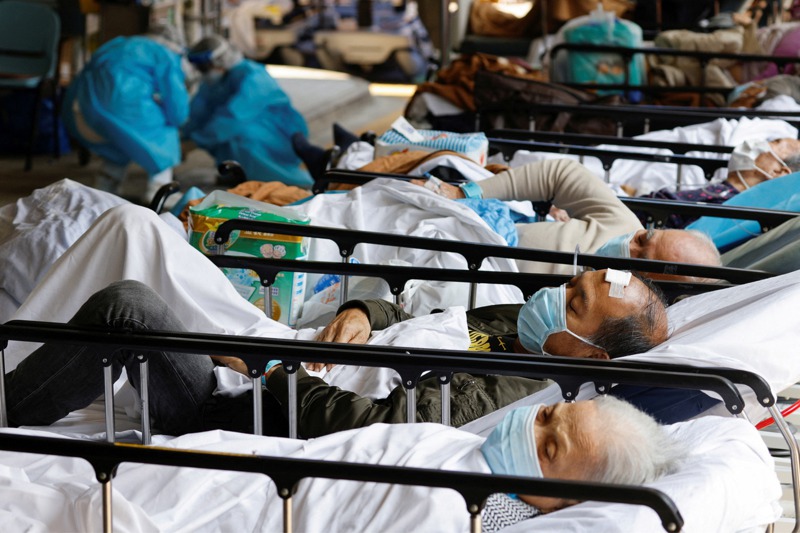 香港從破千例到破萬例，只有16天，圖為香港的病患帶著口罩躺在醫院外臨時搭建的區域。路透