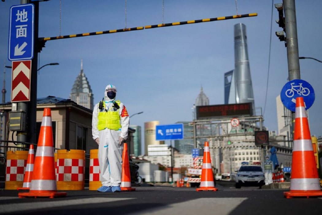 圖為上海為遏制新冠病毒傳播，一名身穿防護服的警察在黃浦江對岸通往浦東地區的隧道入口處守候。 圖／路透社