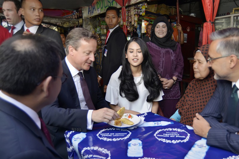 阿雲達（中，白衣者）2015年7月陪來訪的英國首相卡麥隆（左二）在雅加達路邊攤吃點心。美聯社