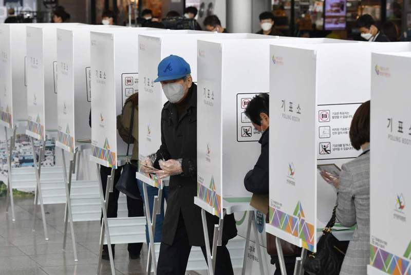 一名南韓男子十日在首爾一個提前投票所投票，依規定戴上口罩和一次性手套。法新社