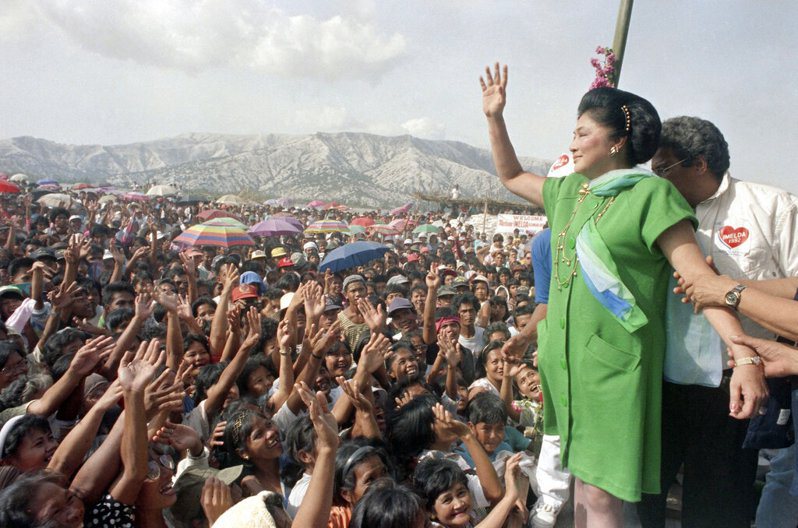 伊美黛在柯拉蓉崛起後，改穿綠洋裝以示與其對立。圖為1991年她結束流亡返菲後，訪問火山噴發災區受到熱烈歡迎。美聯社