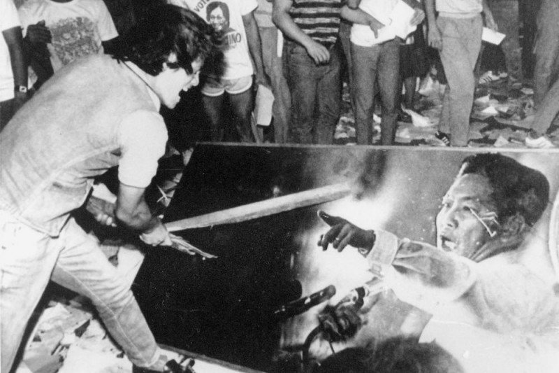1986年菲律賓爆發人民力量革命，抗議群眾破壞獨裁者馬可仕畫像。美聯社
