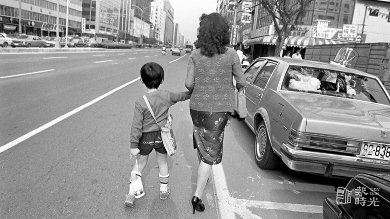 圖說：媽媽牽著小孩走在路上。來源：聯合報。攝影：本報記者。日期：1986-04-18

