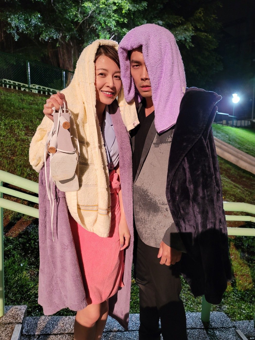 許仁杰（右）、謝京穎為「黃金歲月」拍攝淋雨戲，拍完後披毛巾禦寒。圖／民視提供