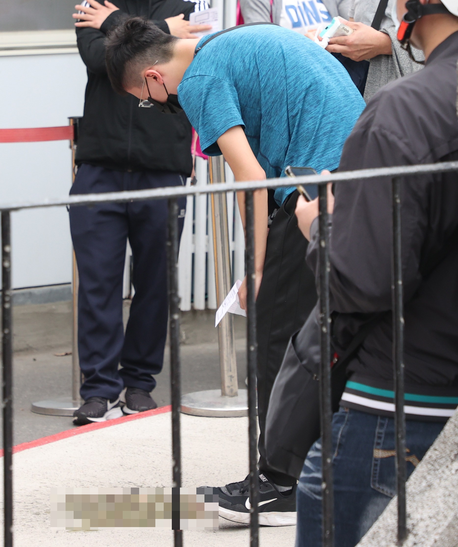 部立台北醫院外昨天大批民眾排隊等候篩檢，有民眾因為身體不適，當場嘔吐。記者陳正興／攝影