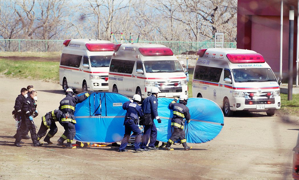 4月24日，消防員和警察從自衛隊的直升機裡接過獲救人員，但部分人員當時已經失去意...