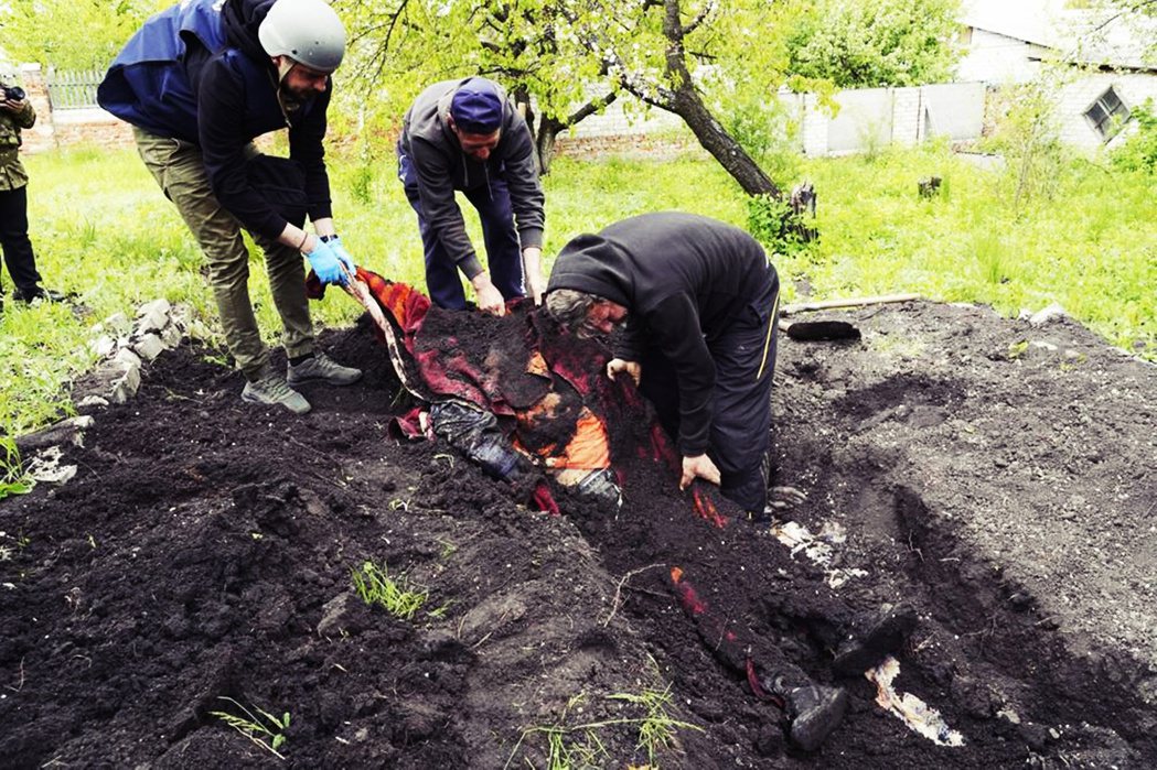 5月11日，在哈爾科夫附近的村落，烏克蘭人員埋葬被俄軍砲擊喪生的當地居民。非即將...