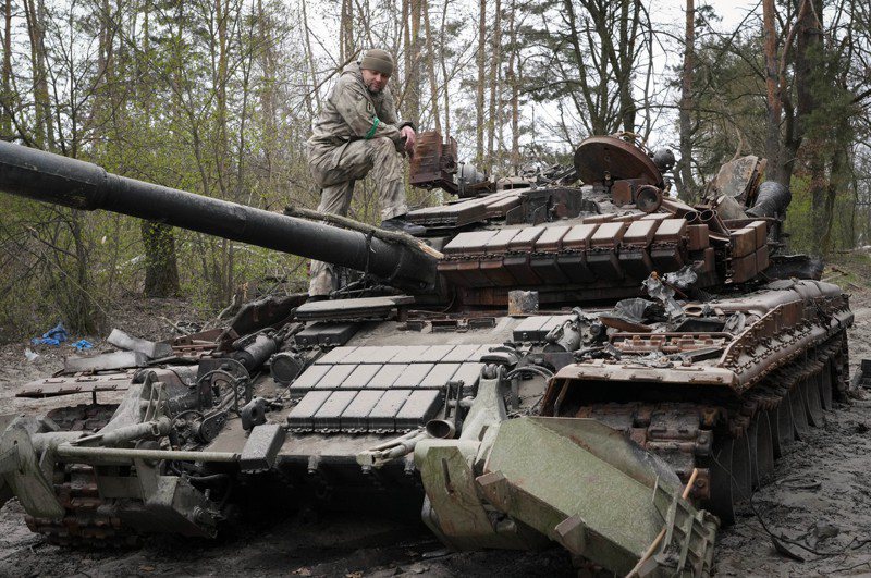 一名烏克蘭軍人今年4月19日在首都基輔附近莫遜鎮察看一輛廢棄的俄軍坦克。美聯社