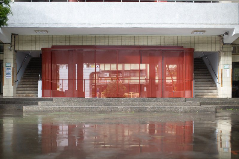 新北市深坑國中翻新老舊學校空間，以大紅色、可動式鐵件隔屏改造原先貼滿海報的川堂。圖／深坑國中總務主任陳衍鈴提供