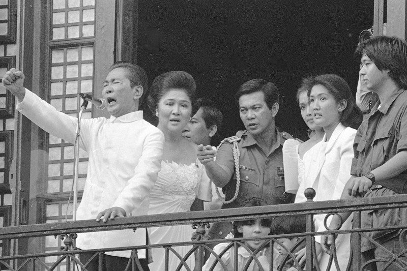 1986年2月25日，老馬可仕（左一）在馬拉坎南宮陽台自行宣誓就職數小時後，帶著伊美黛（左二）、馬可仕（右一）和珠寶現金逃亡美國夏威夷。美聯社