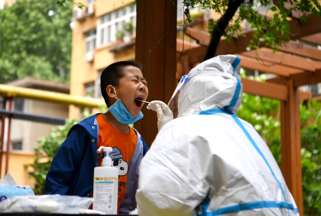圖為河南省鄭州市一處小區，醫務人員正在為小朋友進行核酸採樣。新華社