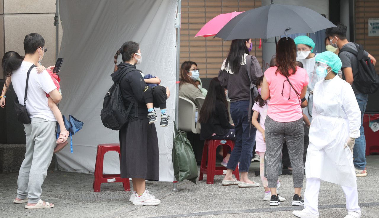 台北市聯醫婦幼院區開啟親子兒童防疫門診，急診入口仍有不少家長抱著孩童等候篩檢。記者陳正興／攝影
