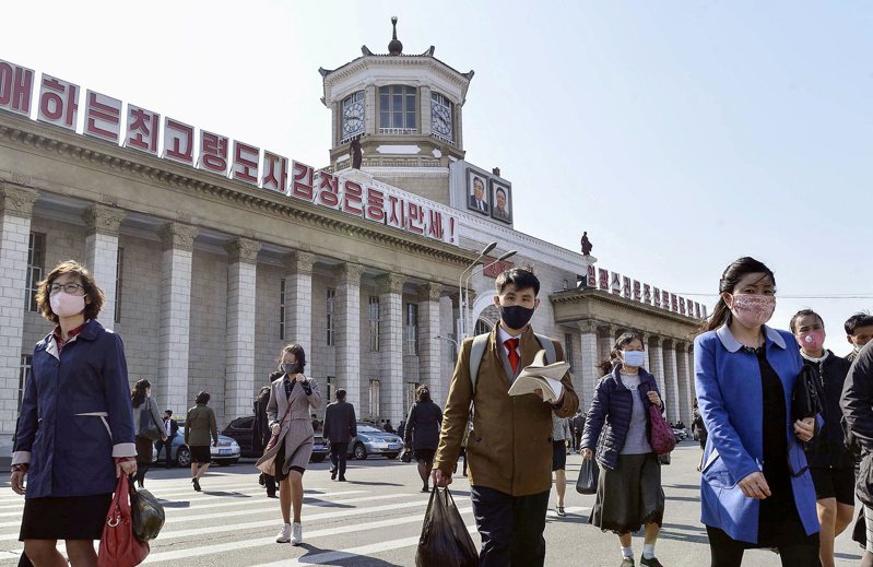 北韓首都平壤民眾2020年4月經過平壤車站前，所有人都戴口罩防疫。路透