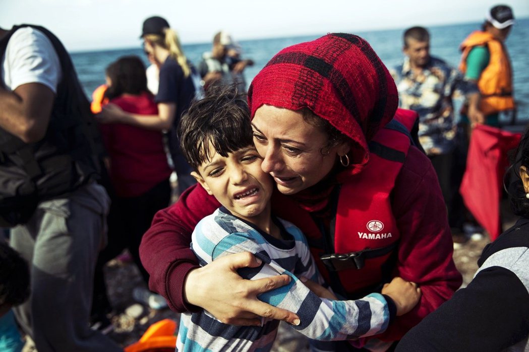 2015年9月11日，一名敘利亞難民在抵達希臘後激動擁抱孩子。 圖／美聯社  ...