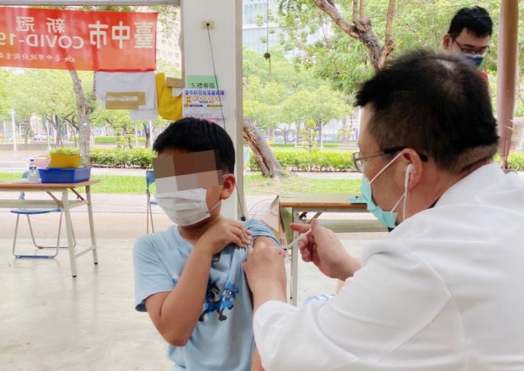 一名學童在家長陪同下，今天到台中市文心森林公園接種站接種疫苗。圖／醫師施勝桓提供