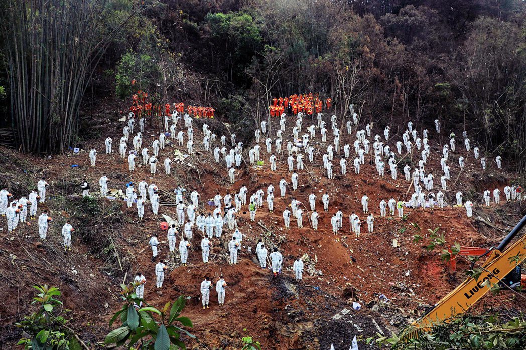 3月27日，救援人員在東航事故現場哀悼。 圖／法新社