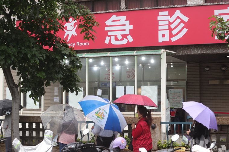 圖為衛福部台北醫院民眾日前頂著傘排隊做PCR情景。報系資料照／記者葉信菉攝影