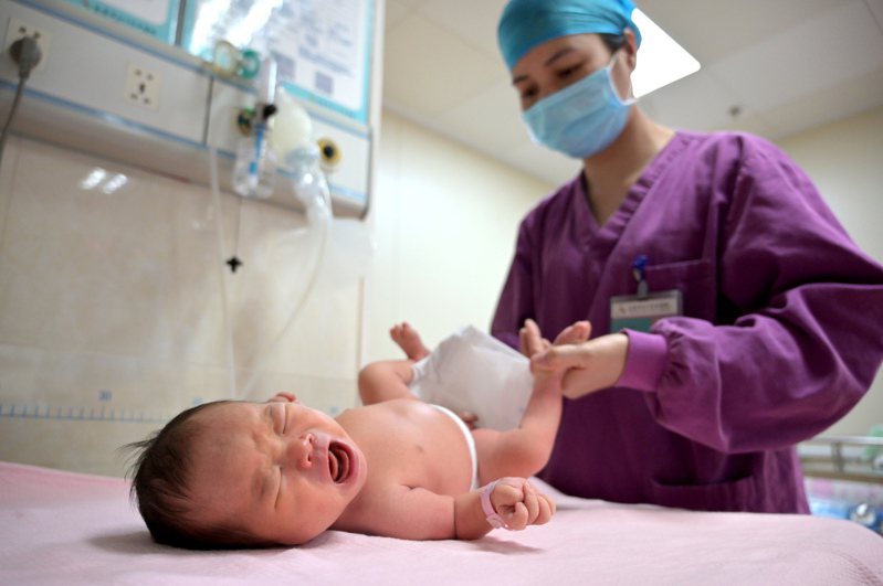 示意圖。圖為5月11日，廣西南寧市紅十字會醫院內，助產士為新生兒進行體格檢查。 中新社