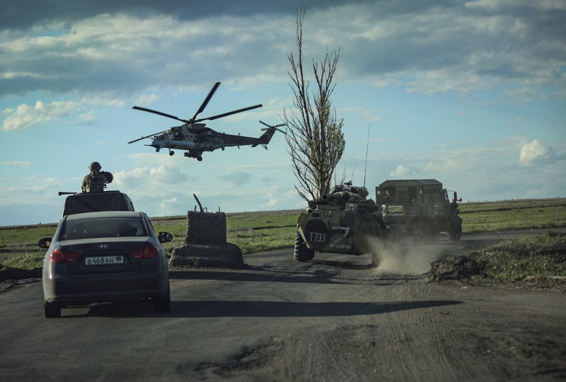 俄羅斯軍方載具跟著撤出馬立波亞速鋼鐵廠的烏克蘭官兵所搭乘巴士（未入鏡），攝於17日。歐新社