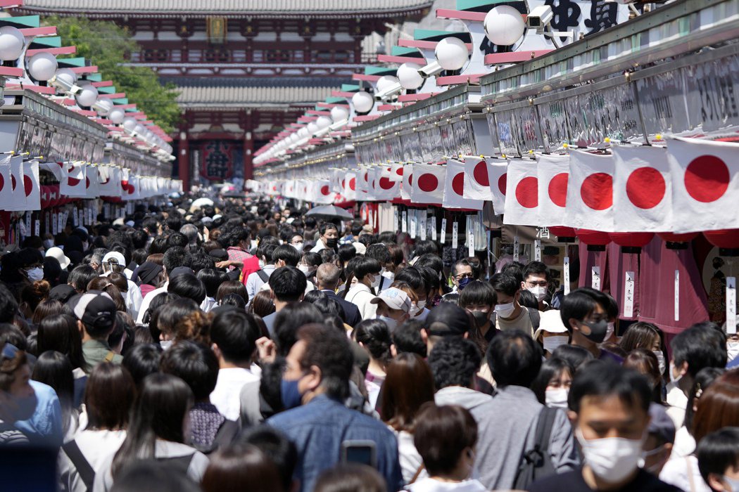 日本政府20日基本決定，在戶外說話較少的步行移動等類似情況時可不必戴口罩。圖為遊...