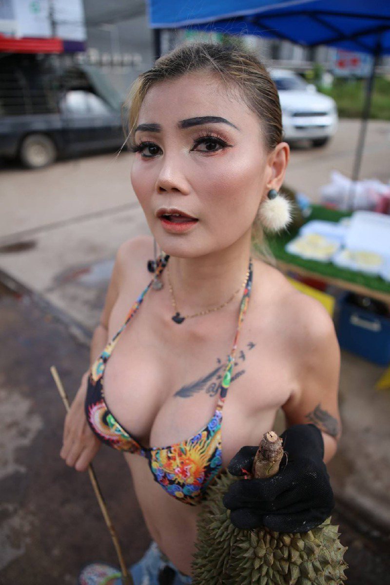 泰国一名地方辣妈为独力抚养3孩，身穿清凉比基尼叫卖榴槤。 图撷自(photo:UDN)
