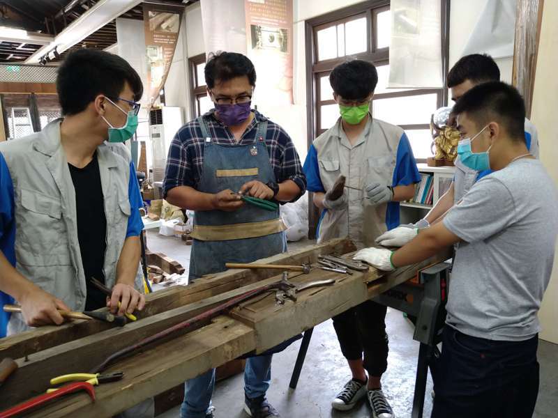 台南市傳統工藝細木作保存者王永源（左二），前往陽明高工傳授榫卯技藝。圖／文資處提供