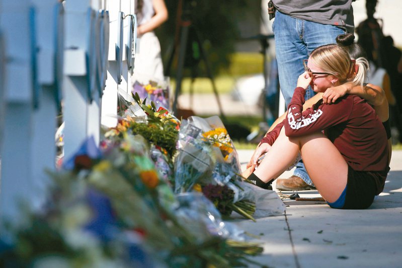 一名女性廿六日在德州小學槍擊案後致哀時傷心欲絕。（美聯社）