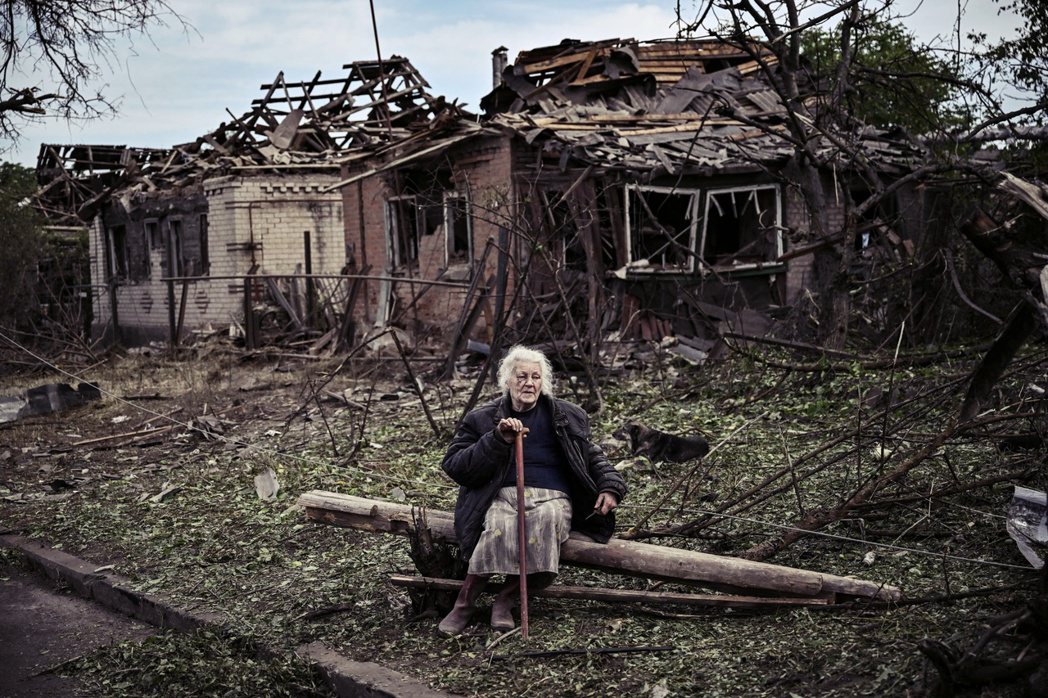 6月5日的頓巴斯地區，一位老奶奶坐在被摧毀的房屋前。 圖／路透社