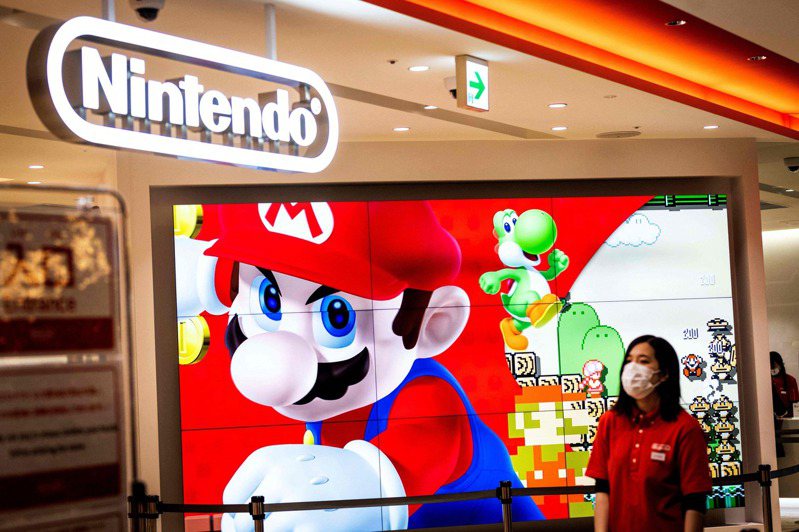 圖為在日本遊戲巨頭任天堂東京的店舖，一名員工站在超級瑪利歐廣告旁邊。（攝影： 法新社