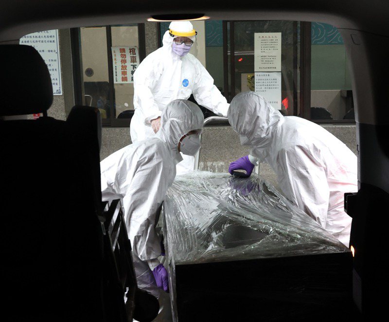 確診者的遺體套上二層的屍袋、入殮，並在將棺木再纏上一層的保鮮膜防止造成疫情擴散。記者黃義書／攝影