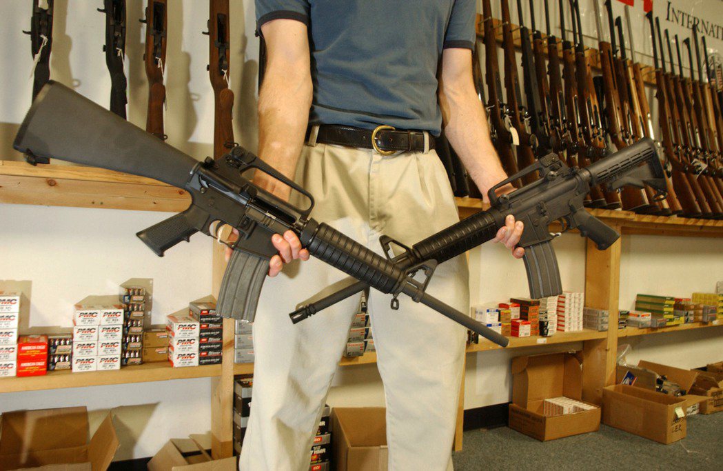 美國槍枝商店裡，一名男子正在展示AR-15步槍。 圖／法新社