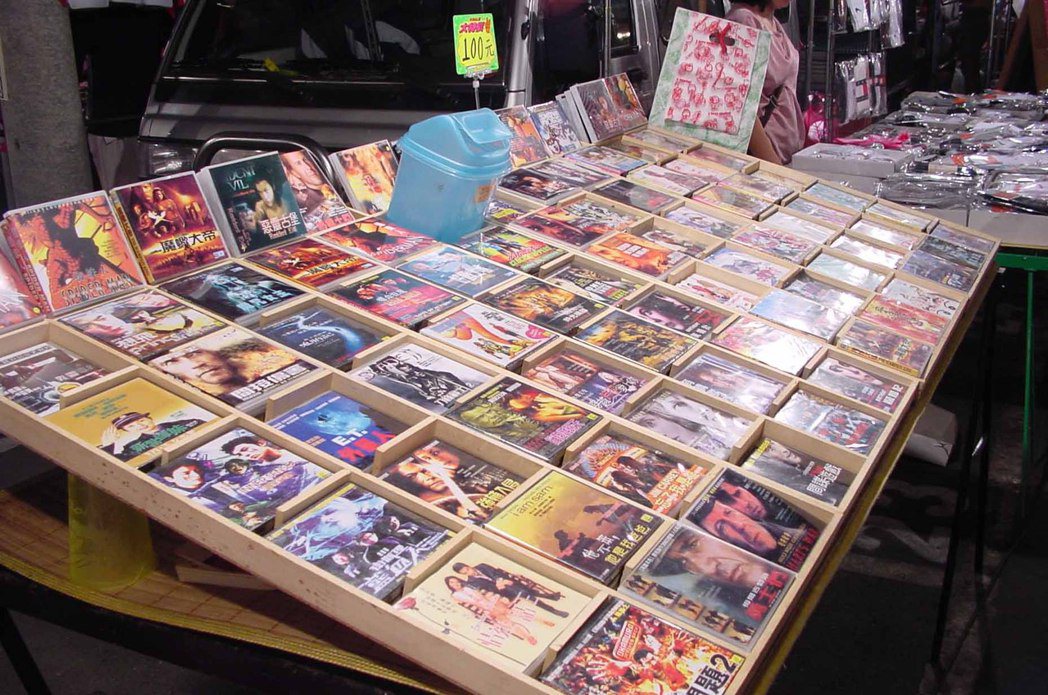 過去，台灣路邊可見攤架上琳瑯滿目的盜版光碟，卻看不到販售人，攤商為逃避取締，僅置放一收錢桶，要購買者自行投錢。 圖／聯合報系資料照片