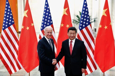 2013年時任美國副總統的拜登（左）造訪中國大陸時，和習近平在北京人民大會堂握手的資料照。 （路透）