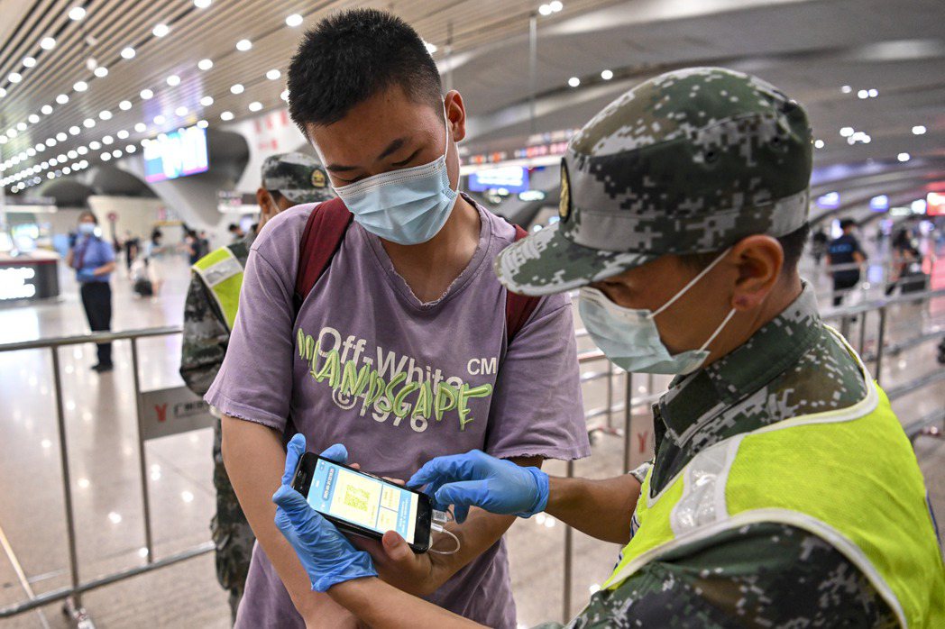 圖為中國廣州南站工作人員檢查進站旅客的「健康碼」及核酸檢測資訊。 圖／中新社