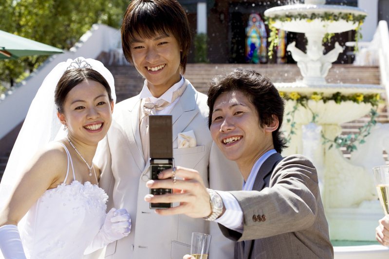 參加婚禮，賓客與新人開心合照，圖為示意圖，非新聞當事人。圖片來源/ingimage
