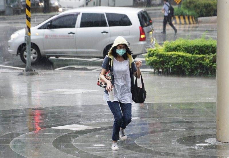 台北市區下午出現強降雨及頻繁雷擊，民眾奔走躲雨。記者盧逸峰／攝影